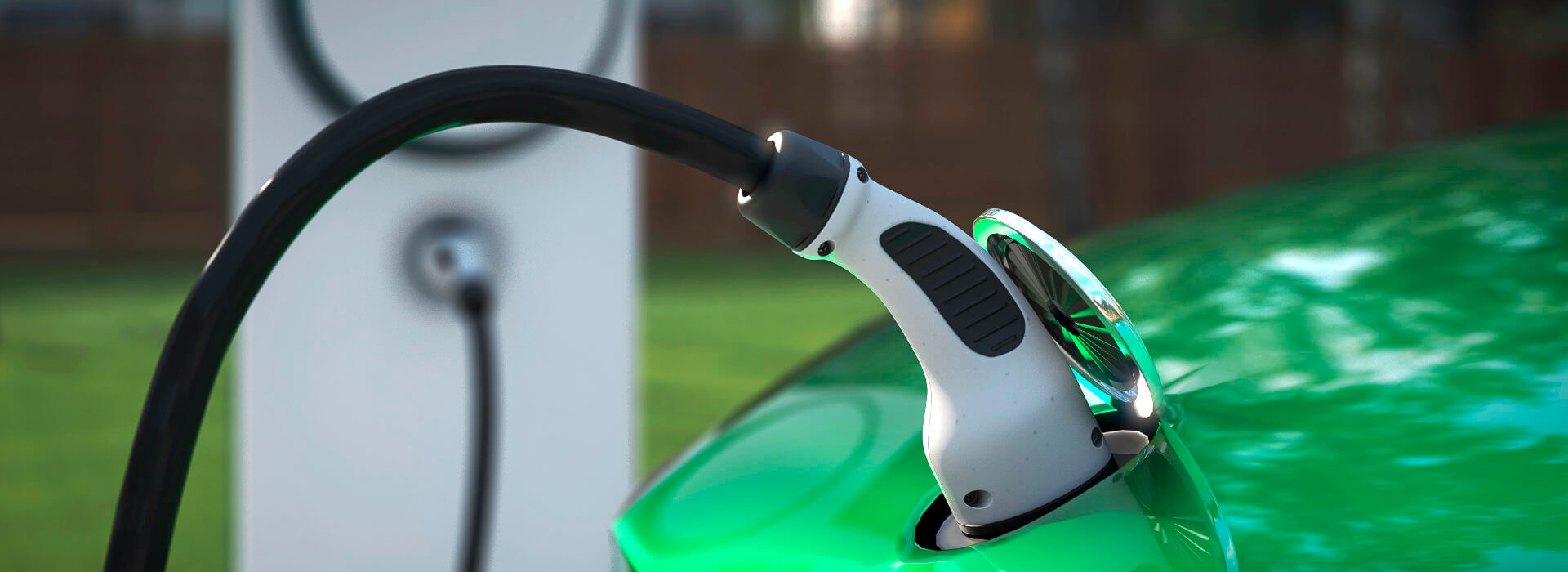 Ladestecker steckt in einem grünen Elektroauto
